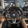 Front view of a BMW G/F chassis, M sport steering wheel in carbon fiber, black perforated leather, driving assistant buttons, m color accents and led shift lights
